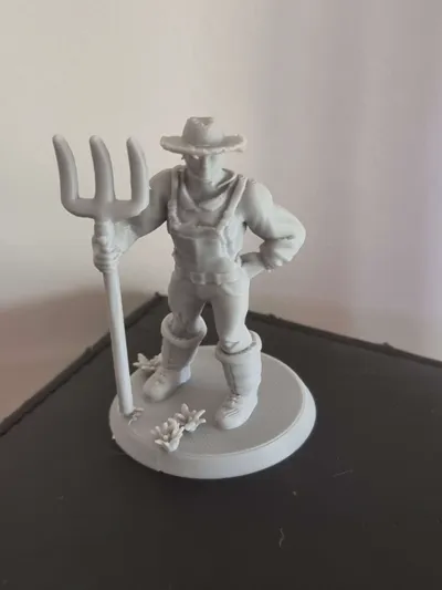The farmer character from the game, 3D printed as a physical miniature holding a pitchfork